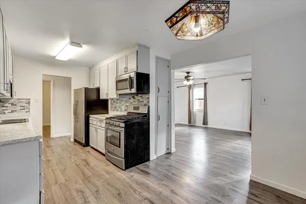 a kitchen with stainless steel appliances kitchen island granite countertop a stove a refrigerator and a microwave