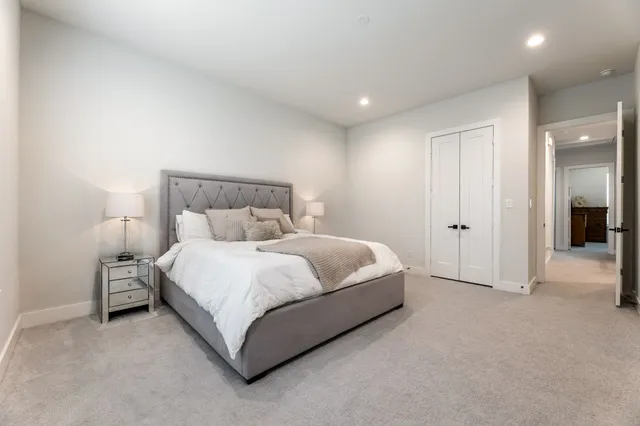 a spacious bedroom with a bed and a lamp