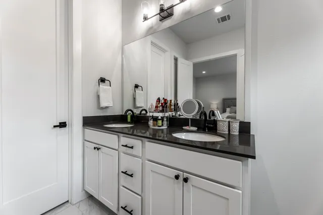 a bathroom with double sink and a mirror