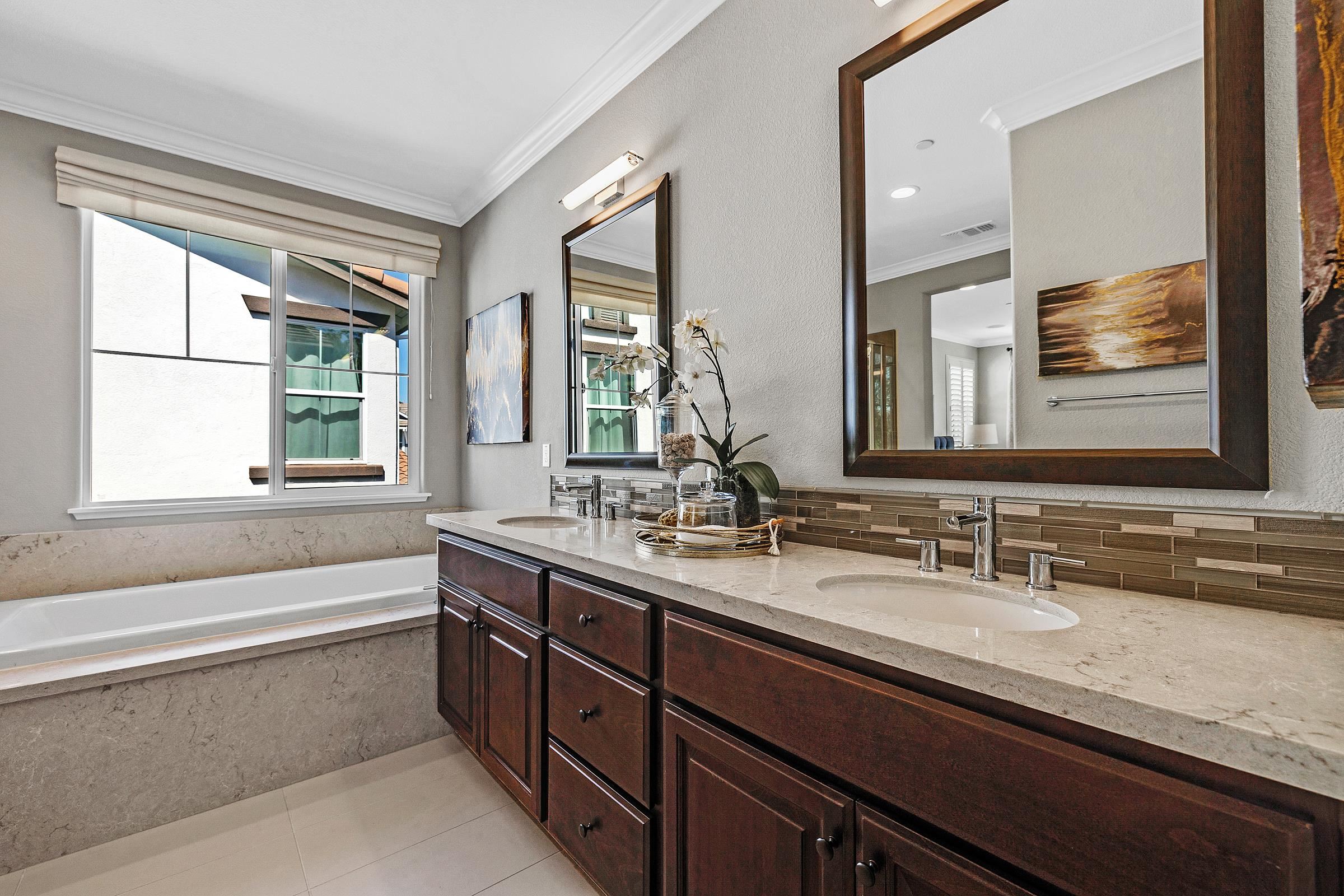 883 Barney Common Livermore, CA 94551 - Photo 26 of 38 a bathroom with a granite countertop sink mirror and a bathtub