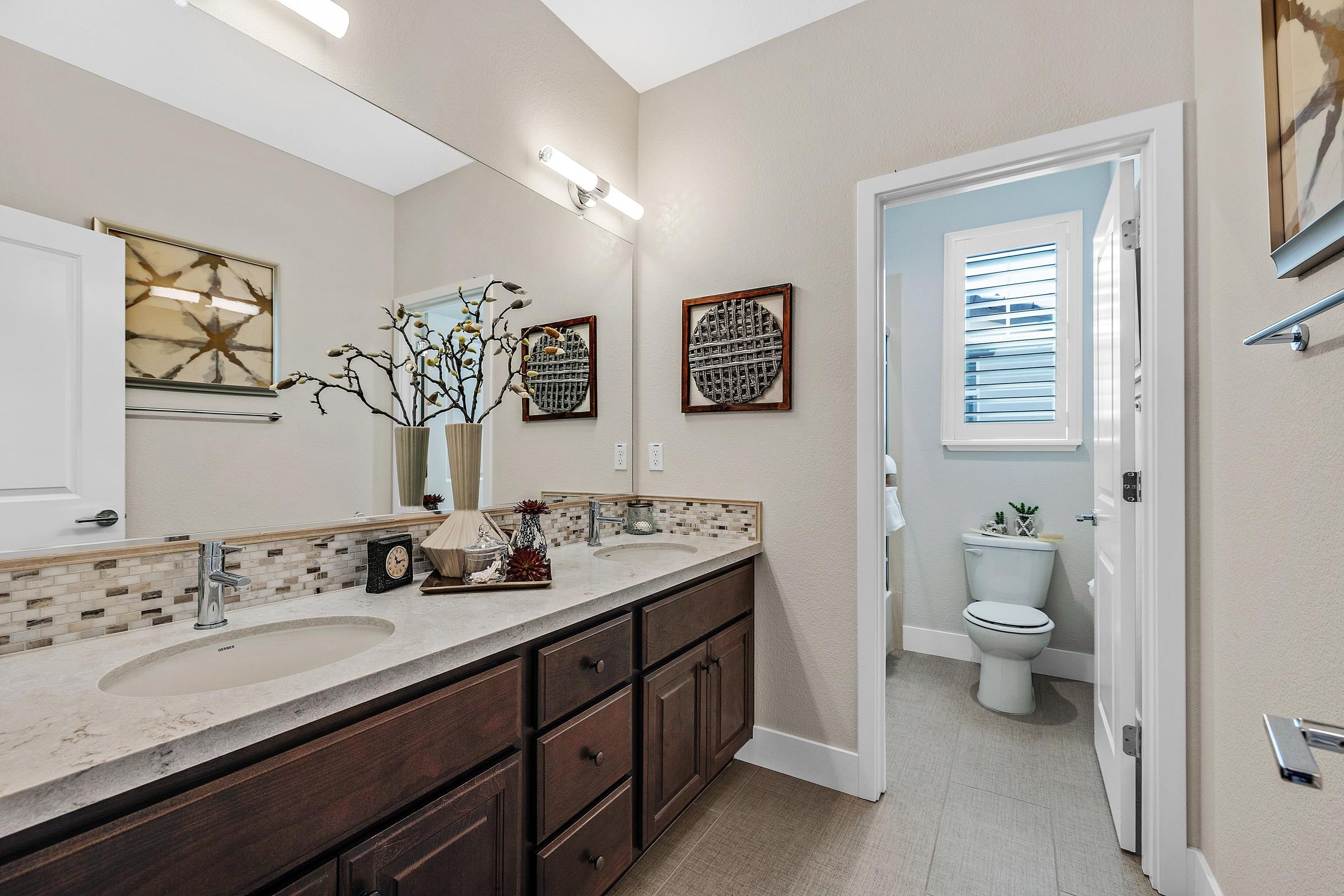 883 Barney Common Livermore, CA 94551 - Photo 31 of 38 a bathroom with a double vanity sink toilet and a mirror