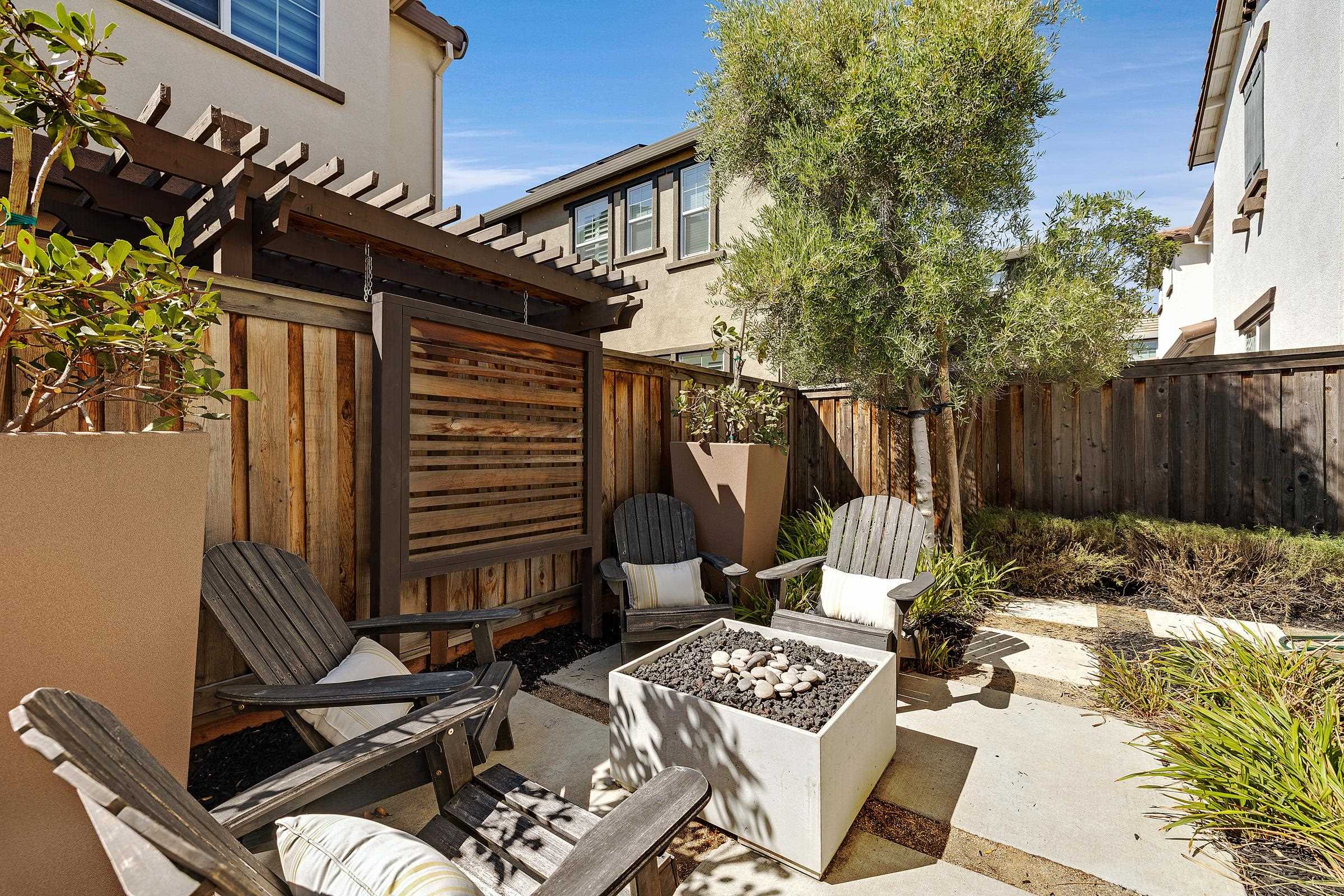 883 Barney Common Livermore, CA 94551 - Photo 37 of 38 a view of a patio with table and chairs with wooden fence and plants