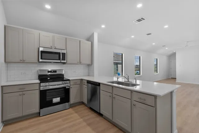 a kitchen with sink a microwave and cabinets
