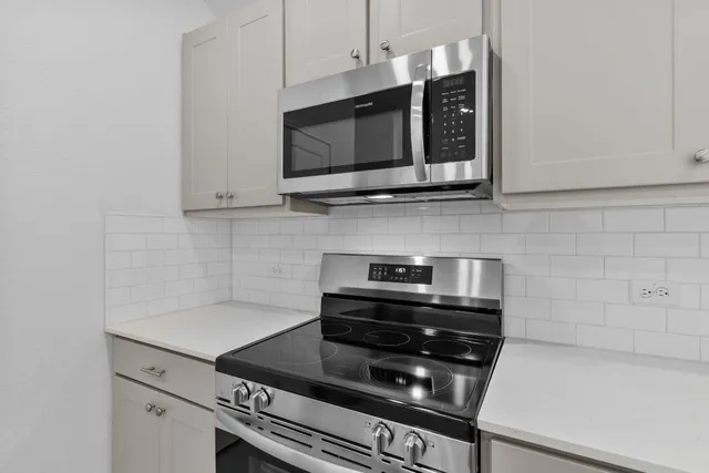 a kitchen with stainless steel appliances a stove a microwave and cabinets