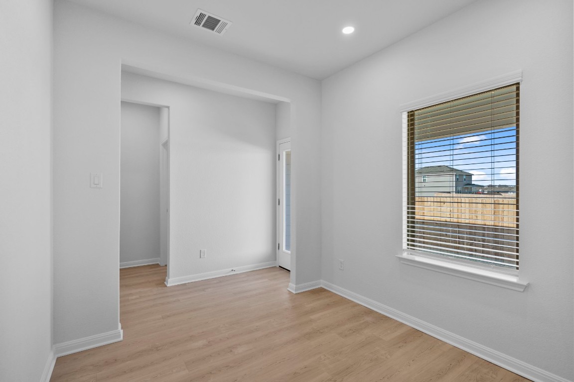129 Hatari Trail Jarrell, TX 76537 - Photo 22 of 33 a view of an empty room with wooden floor and a window