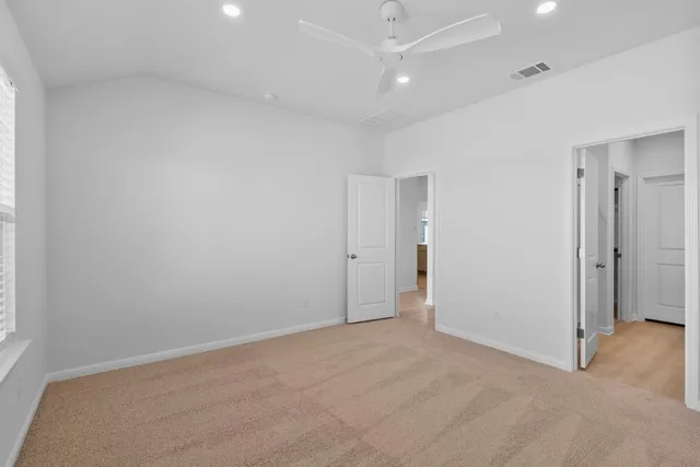 an empty room with an entryway and fan