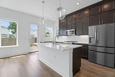 a kitchen with kitchen island a counter top space stainless steel appliances and a window