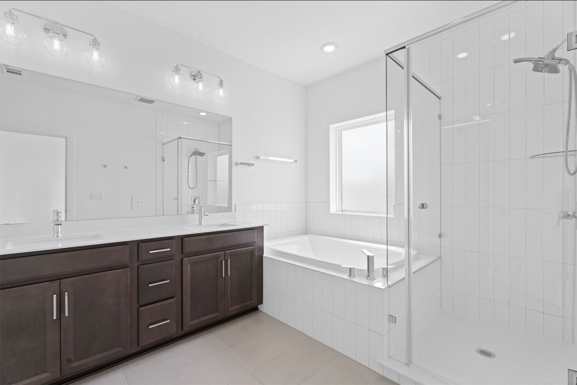 609 Terrier Trail Austin, TX 78745 - Photo 9 of 26 a bathroom with a tub a sink shower and mirror