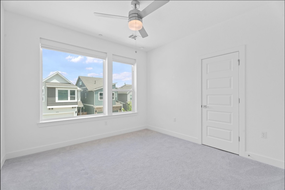 609 Terrier Trail Austin, TX 78745 - Photo 10 of 26 an empty room with windows and fan