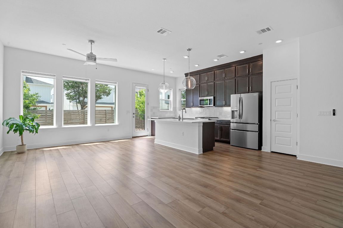 609 Terrier Trail Austin, TX 78745 - Photo 25 of 26 a kitchen with stainless steel appliances granite countertop a stove top oven a sink and dishwasher with wooden floor