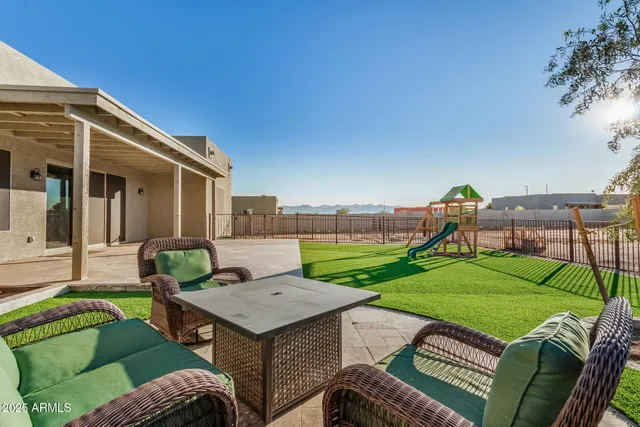 a backyard of a house with table and chairs