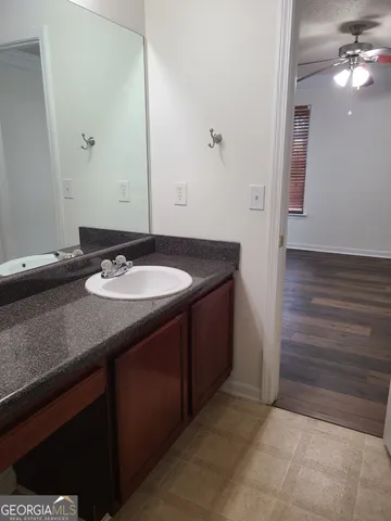 a bathroom with a granite countertop sink a mirror and vanity