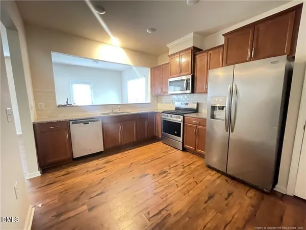 a kitchen with granite countertop stainless steel appliances a refrigerator and a sink