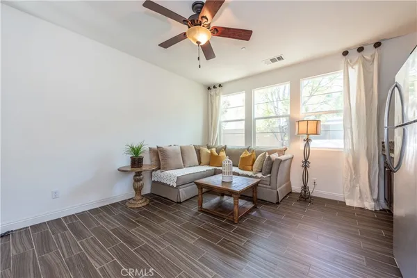 a living room with furniture a window and a ceiling fan