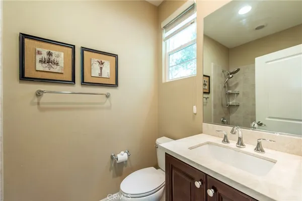 a bathroom with a granite countertop toilet sink and mirror