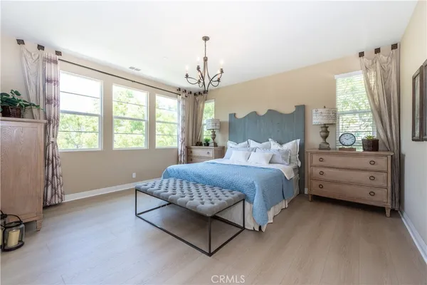 a bedroom with a bed and a chandelier