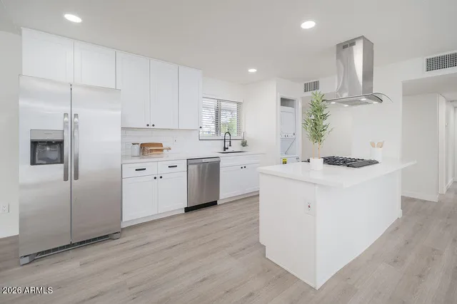 a kitchen with white cabinets and stainless steel appliances