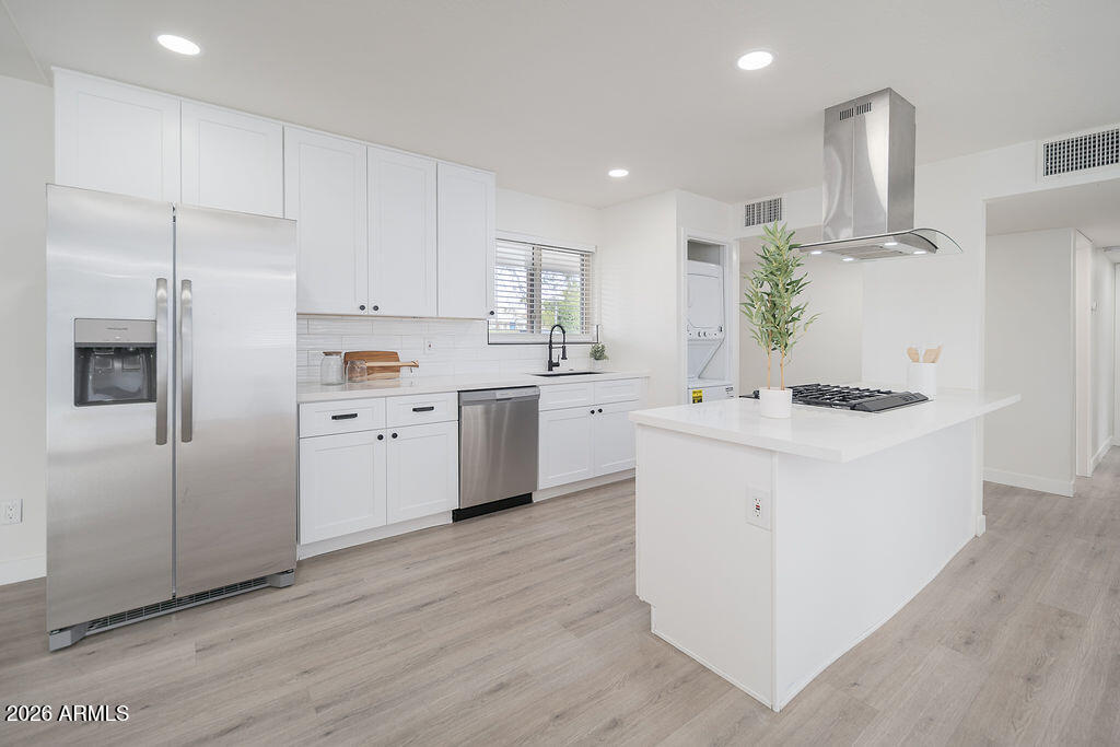 4653 East Almeria Road Phoenix, AZ 85008 - Photo 5 of 18 a kitchen with white cabinets and stainless steel appliances