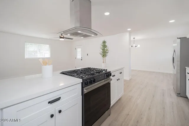 a kitchen with a stove and a wooden floor
