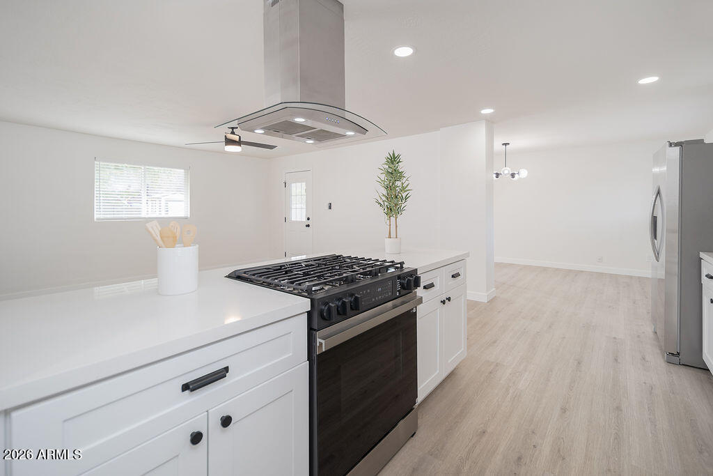 4653 East Almeria Road Phoenix, AZ 85008 - Photo 6 of 18 a kitchen with a stove and a wooden floor