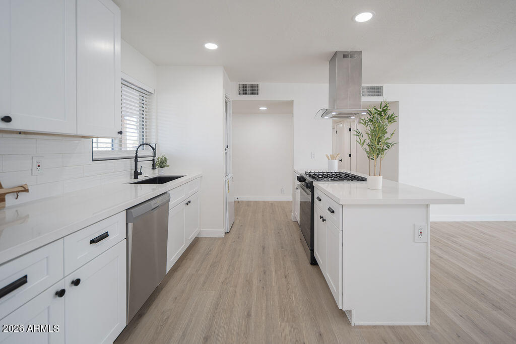 4653 East Almeria Road Phoenix, AZ 85008 - Photo 7 of 18 a kitchen with granite countertop a sink stove and cabinets