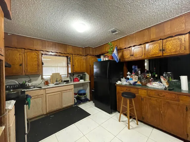 a kitchen with refrigerator and cabinets