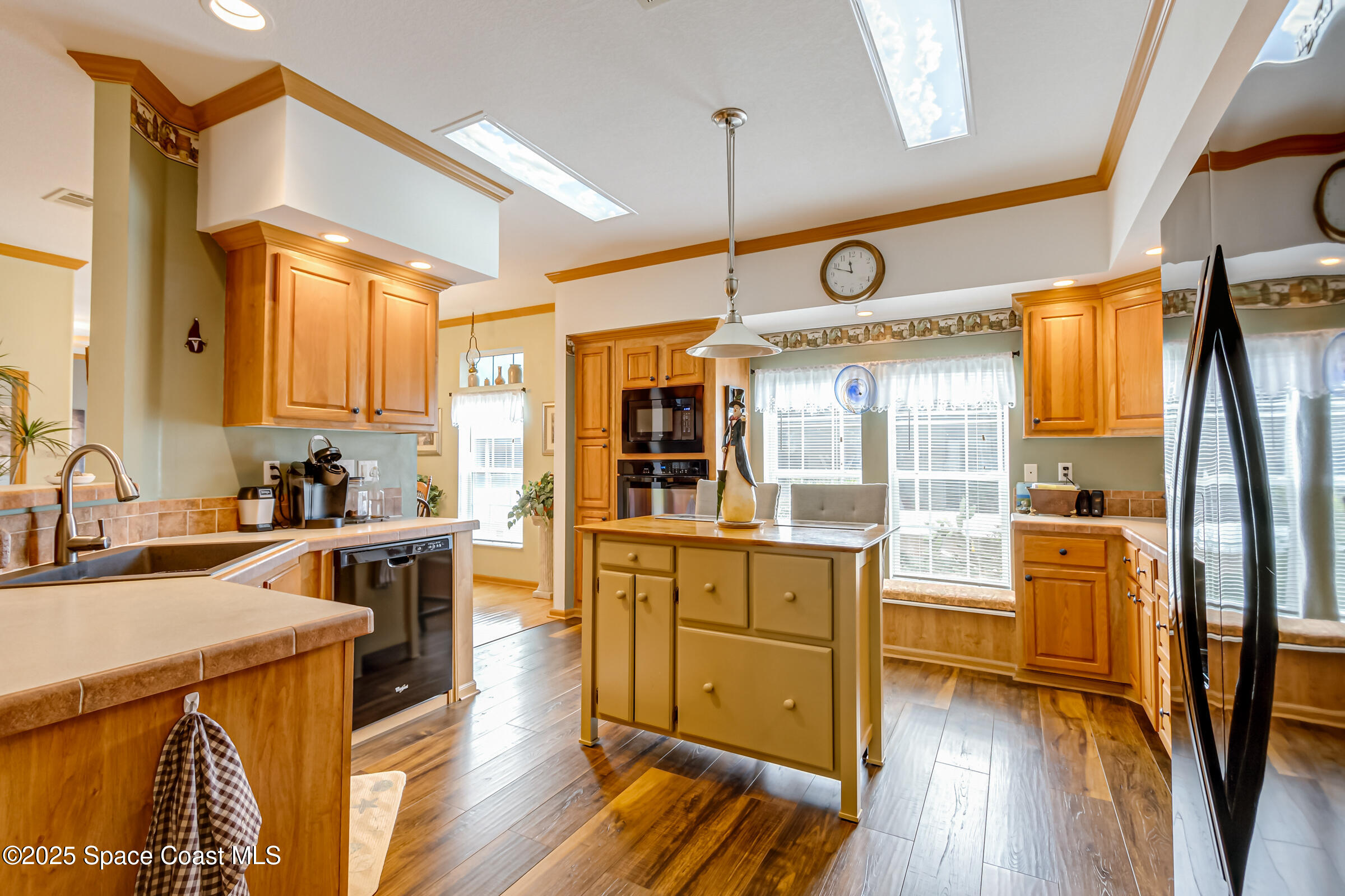 694 Outer Drive, Unit 184 Cocoa, FL 32926 - Photo 12 of 38 a kitchen with stainless steel appliances granite countertop a refrigerator a sink dishwasher a stove and white countertops with wooden floor