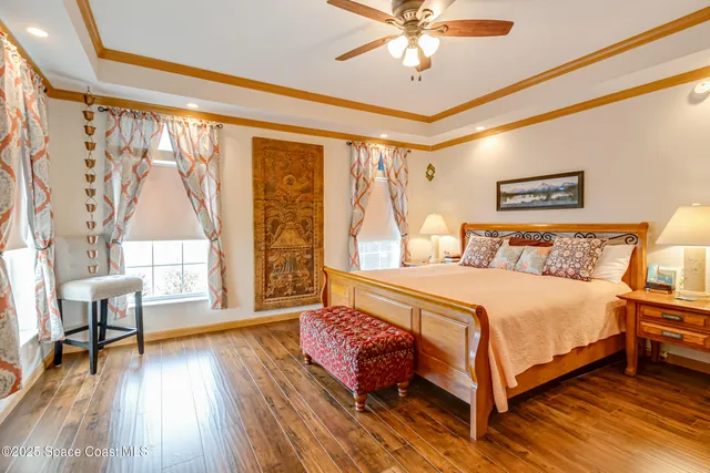 a bedroom with a large bed and a chandelier