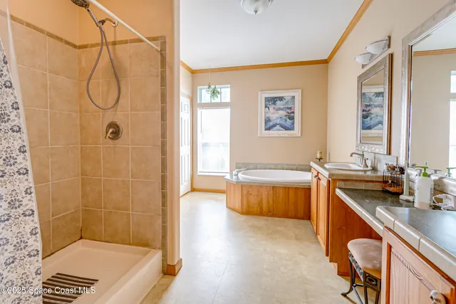 a bathroom with a tub a sink a mirror and a shower