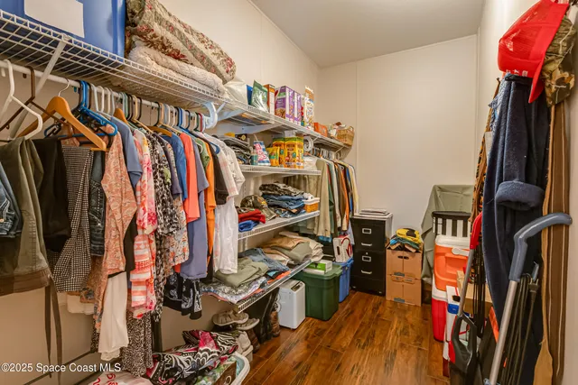 a view of walk in closet with clothes and shoes