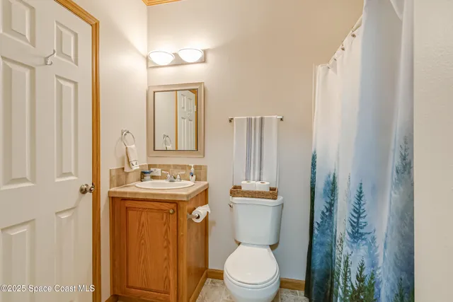 a bathroom with a toilet a sink and a mirror