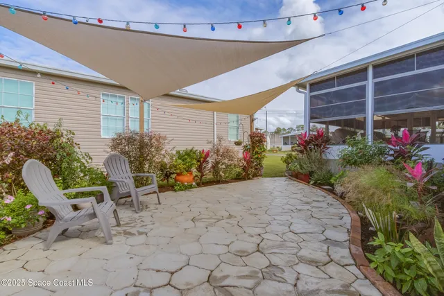 a view of a chair and table in backyard of the house