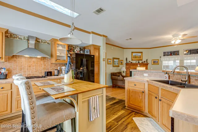 a kitchen with stainless steel appliances kitchen island granite countertop a sink and cabinets