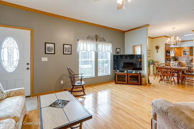 a living room with furniture and a flat screen tv with wooden floor