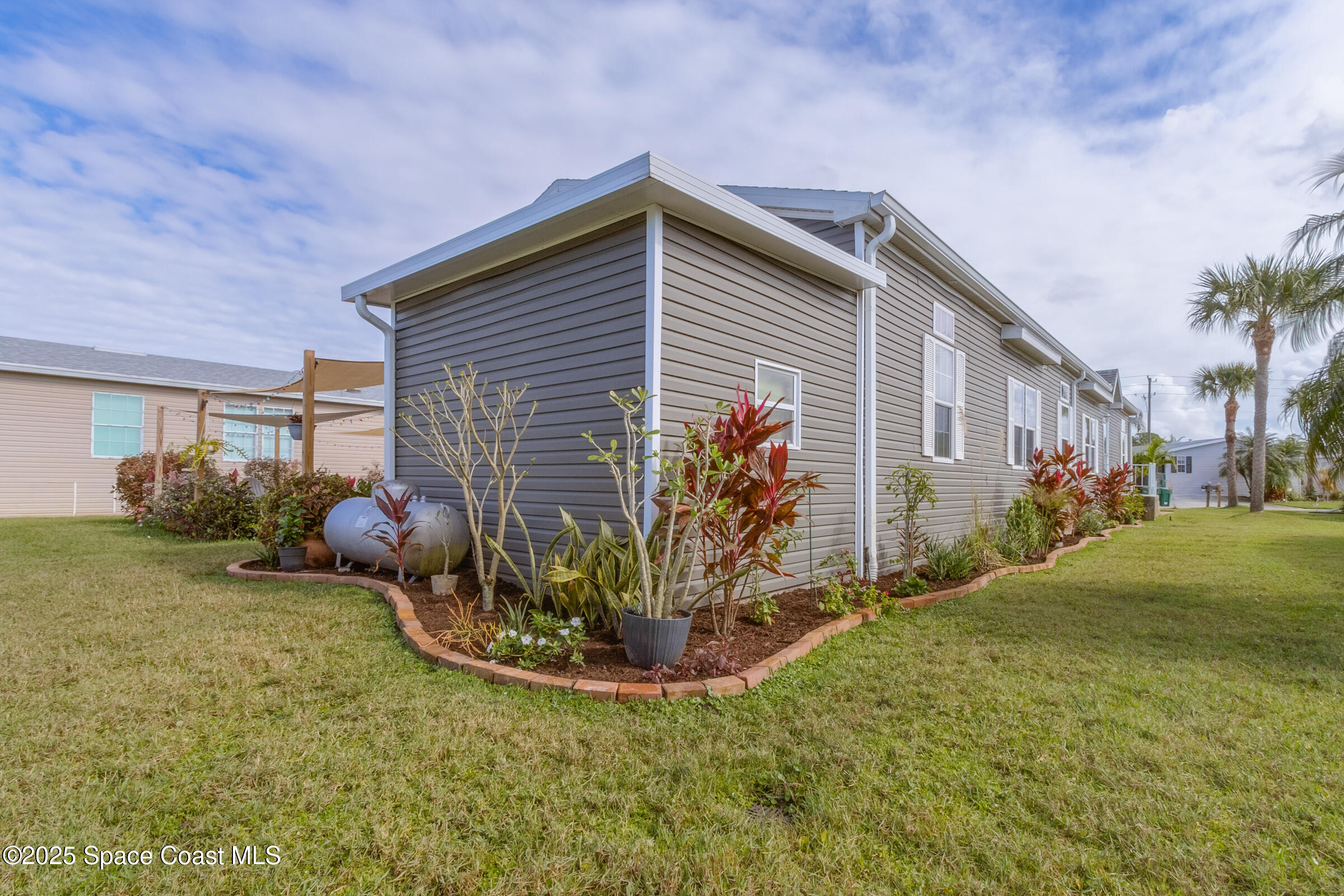 694 Outer Drive, Unit 184 Cocoa, FL 32926 - Photo 6 of 38 a view of a house with a yard and a garage