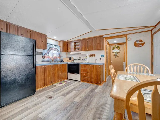 a kitchen with stainless steel appliances granite countertop a refrigerator a stove and a wooden cabinets