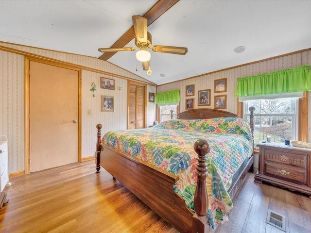 a bedroom with a bed lamp and a large window