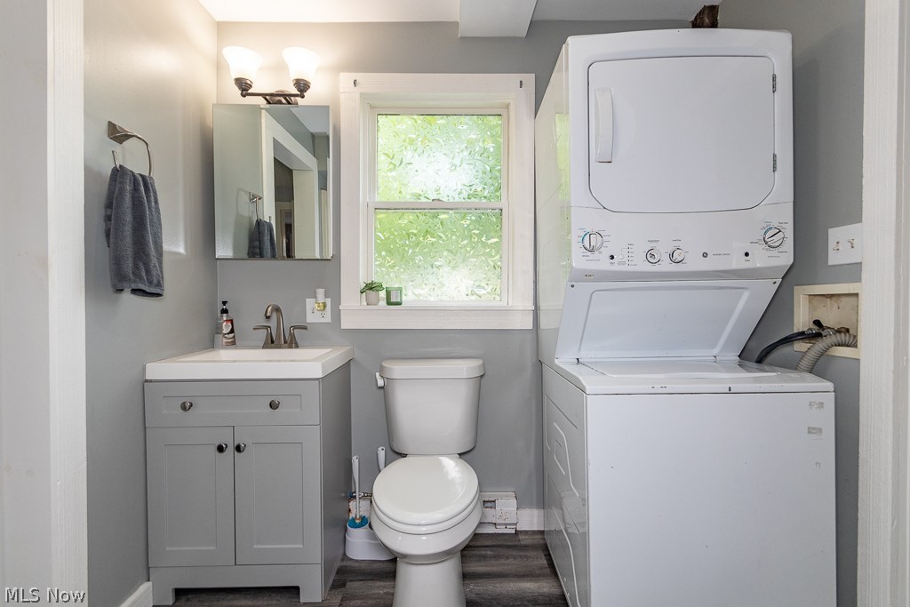 16506 Leroy Thompson Road Thompson, OH 44086 - Photo 21 of 41 Bathroom with vanity, stacked washer / dryer, wood-type flooring, and toilet