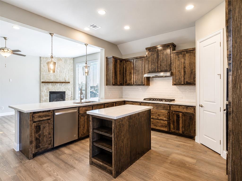 6209 Cupleaf Road Flower Mound, TX 76226 - Photo 12 of 29 Kitchen featuring dark wood-finish cabinetry, white countertops, a subway tile backsplash, and stainless steel appliances