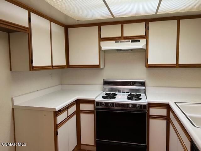 1225 Fitzgerald Road, Unit E Simi Valley, CA 93065 - Photo 7 of 30 a kitchen with stainless steel appliances granite countertop a stove and a microwave