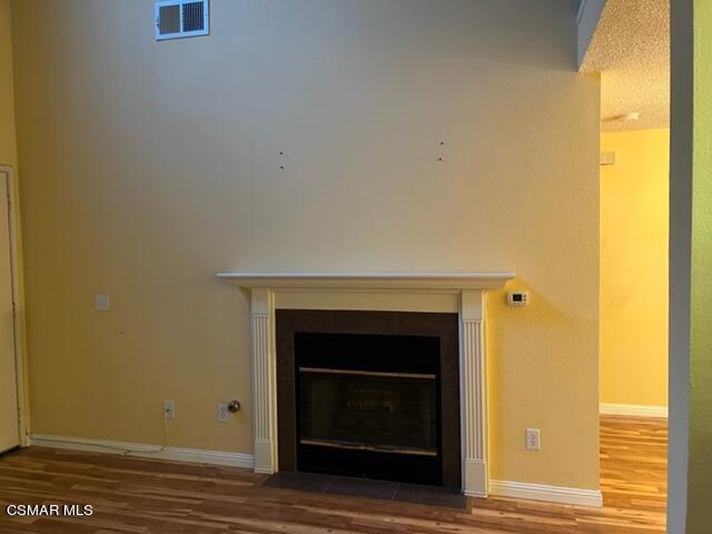 1225 Fitzgerald Road, Unit E Simi Valley, CA 93065 - Photo 9 of 30 a view of empty room with a fireplace and wooden floor