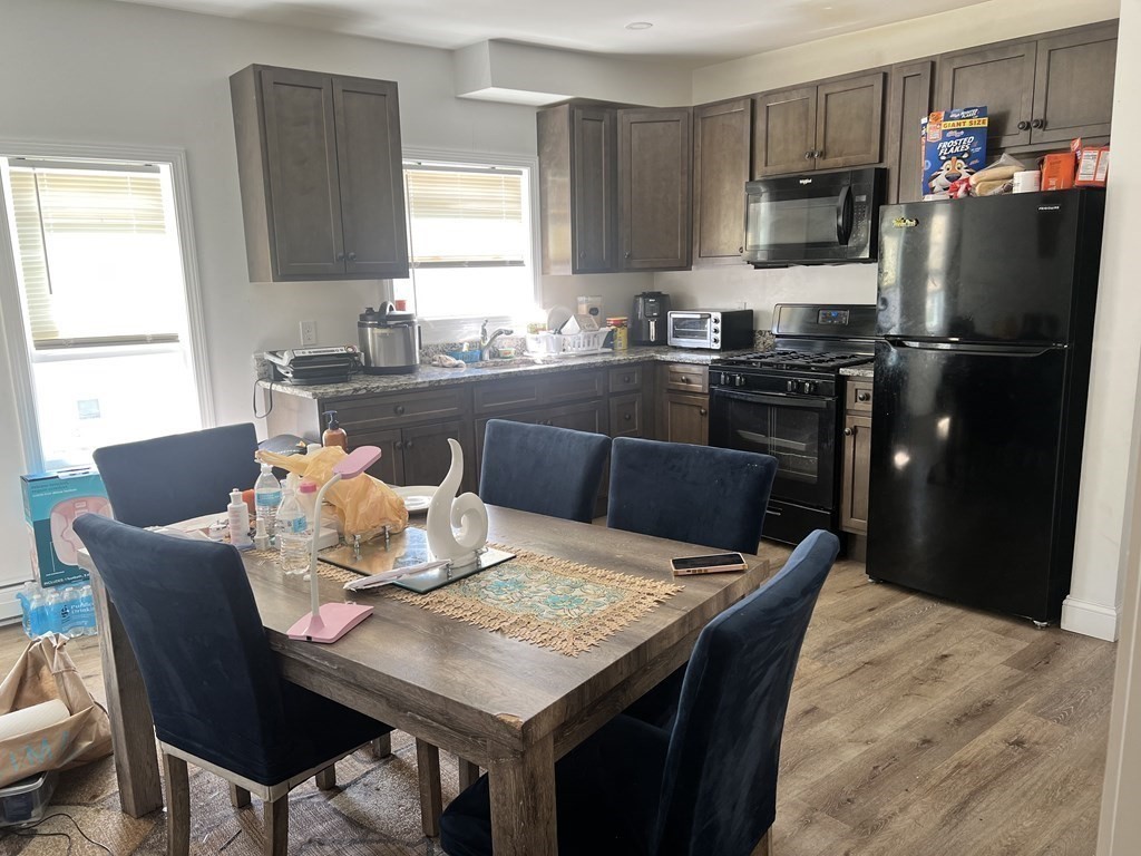 95-97 Tenney Street Methuen, MA 01844 - Photo 10 of 19 a kitchen with a table chairs refrigerator and microwave