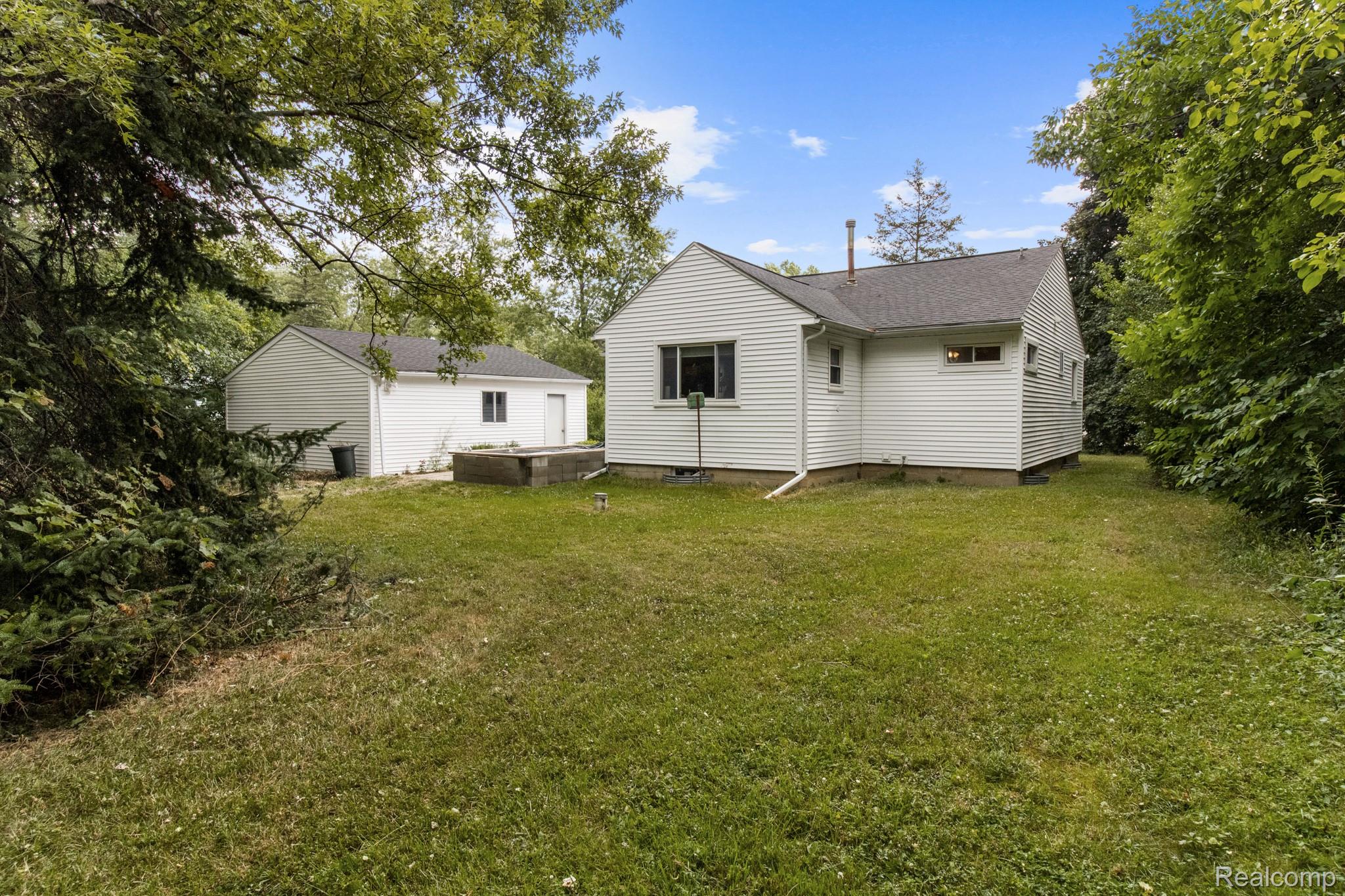 7330 Embury Road Grand Blanc, MI 48439 - Photo 26 of 29 Expansive green lawn surrounds the white siding residence and detached garage