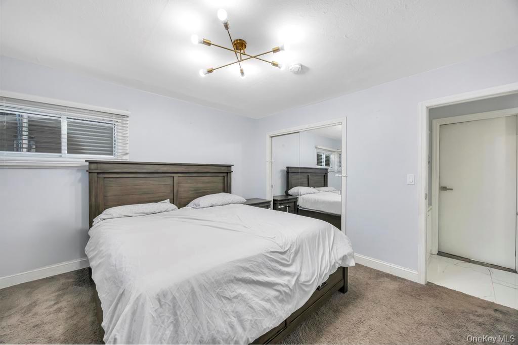 111 Blacksmith Road East Levittown, NY 11756 - Photo 9 of 14 Bedroom with a closet, carpet flooring, and a chandelier