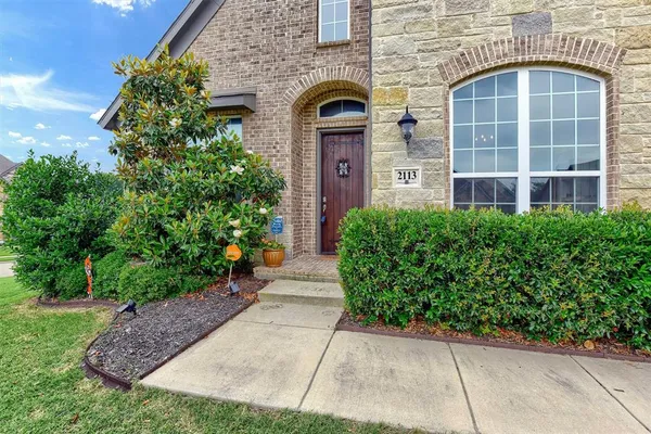 front view of a brick house with a yard