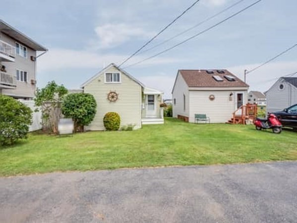 554 Winnacunnet Road, Unit A Hampton, NH 03842 - Photo 2 of 19 a front view of a house with a yard and garage