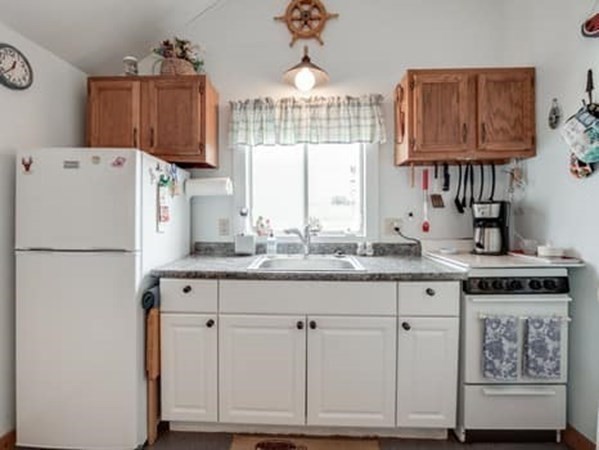 554 Winnacunnet Road, Unit A Hampton, NH 03842 - Photo 7 of 19 a kitchen with granite countertop a refrigerator a sink and white cabinets