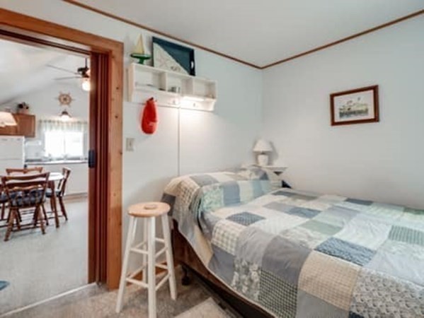 554 Winnacunnet Road, Unit A Hampton, NH 03842 - Photo 8 of 19 a bedroom with a bed and a table in it
