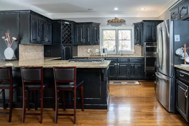 a kitchen with stainless steel appliances granite countertop a stove a sink and a refrigerator