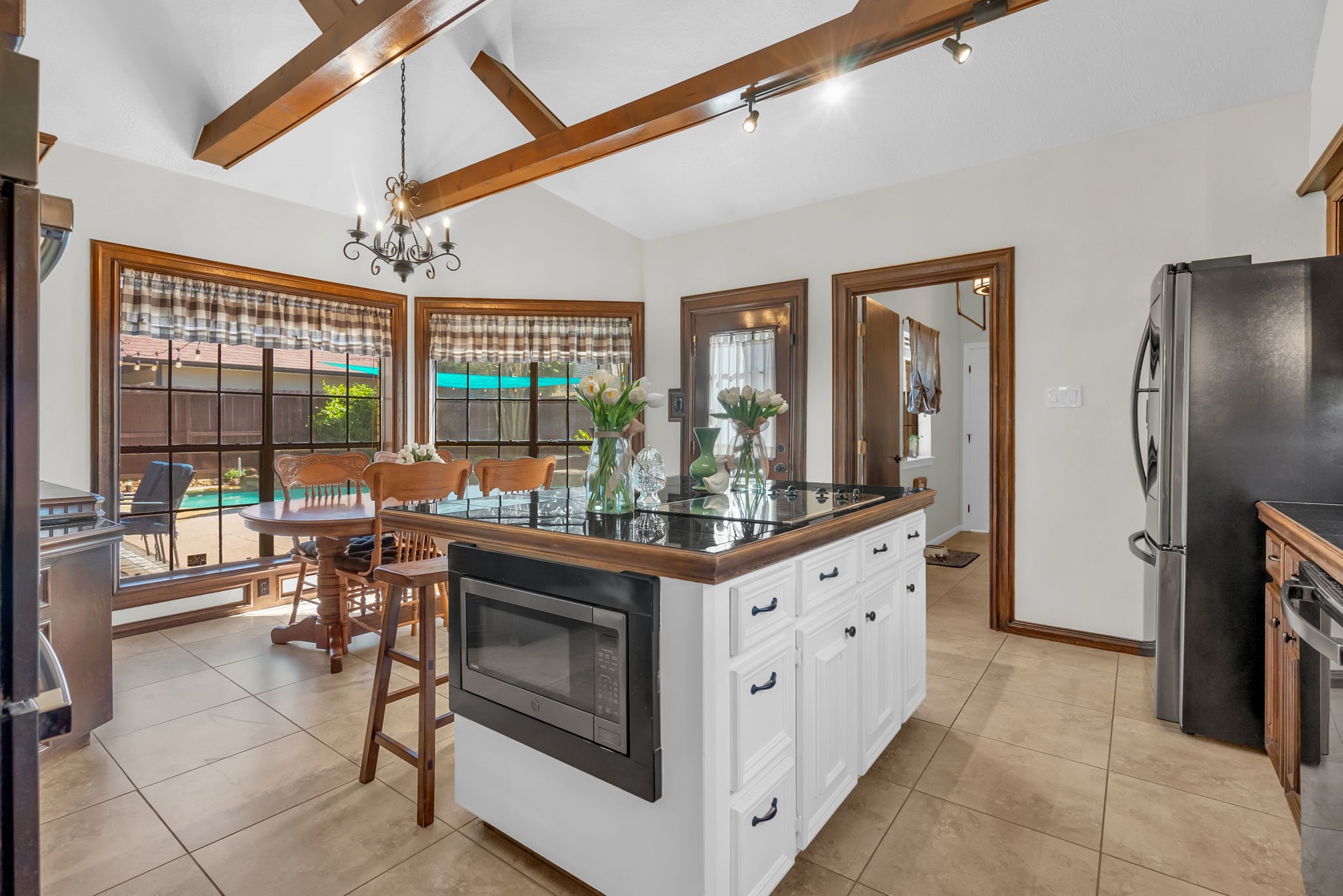 6034 Oak Creek Lane Spring, TX 77379 - Photo 13 of 42 This Kitchen features custom cabinets, granite countertops, island with cooktop, and a Wooden Beamed Ceiling! 6034 Oak Creek Ln., Spring, TX 77379
